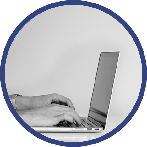 Eine Person tippt auf der Tastatur eines Laptops.