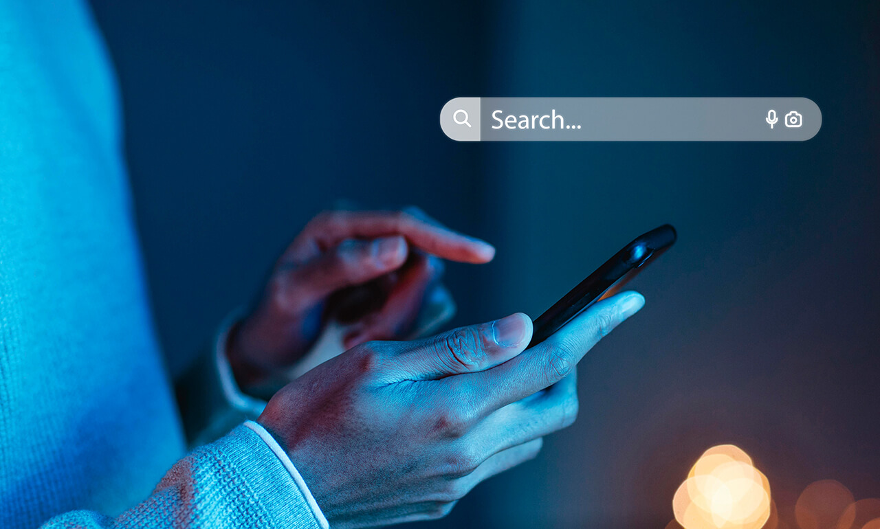 Zwei Hände, die ein Smartphone halten und einer virtuellen Suchmaske darüber.